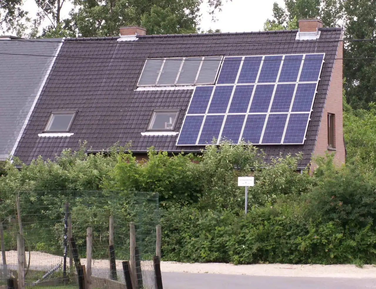 Trimming Trees for Solar Panels in Tallahassee — What to Cut, What to Keep - Tallahassee Tree Service Rooftop solar array on a home with screening vegetation nearby, the shading balance weighed before trimming trees in Tallahassee, FL